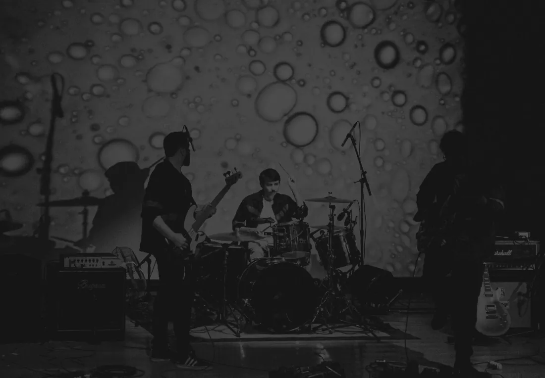 A banda tocando diante de uma projeção cheia de bolhas